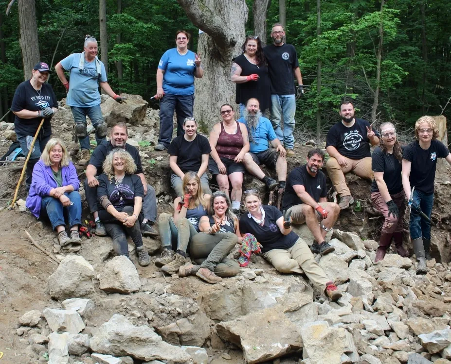 Rockhounding field trip group sitting together at a rocky collecting area.